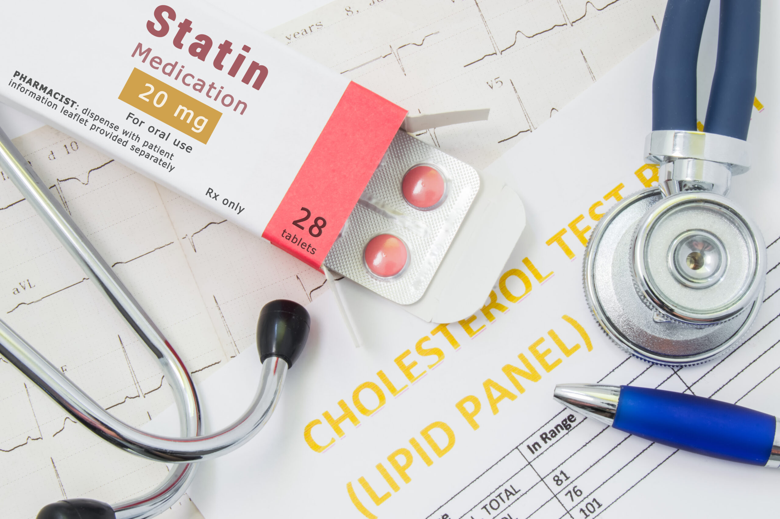 Statin drug box on top of EKG tracing with blue stethoscope